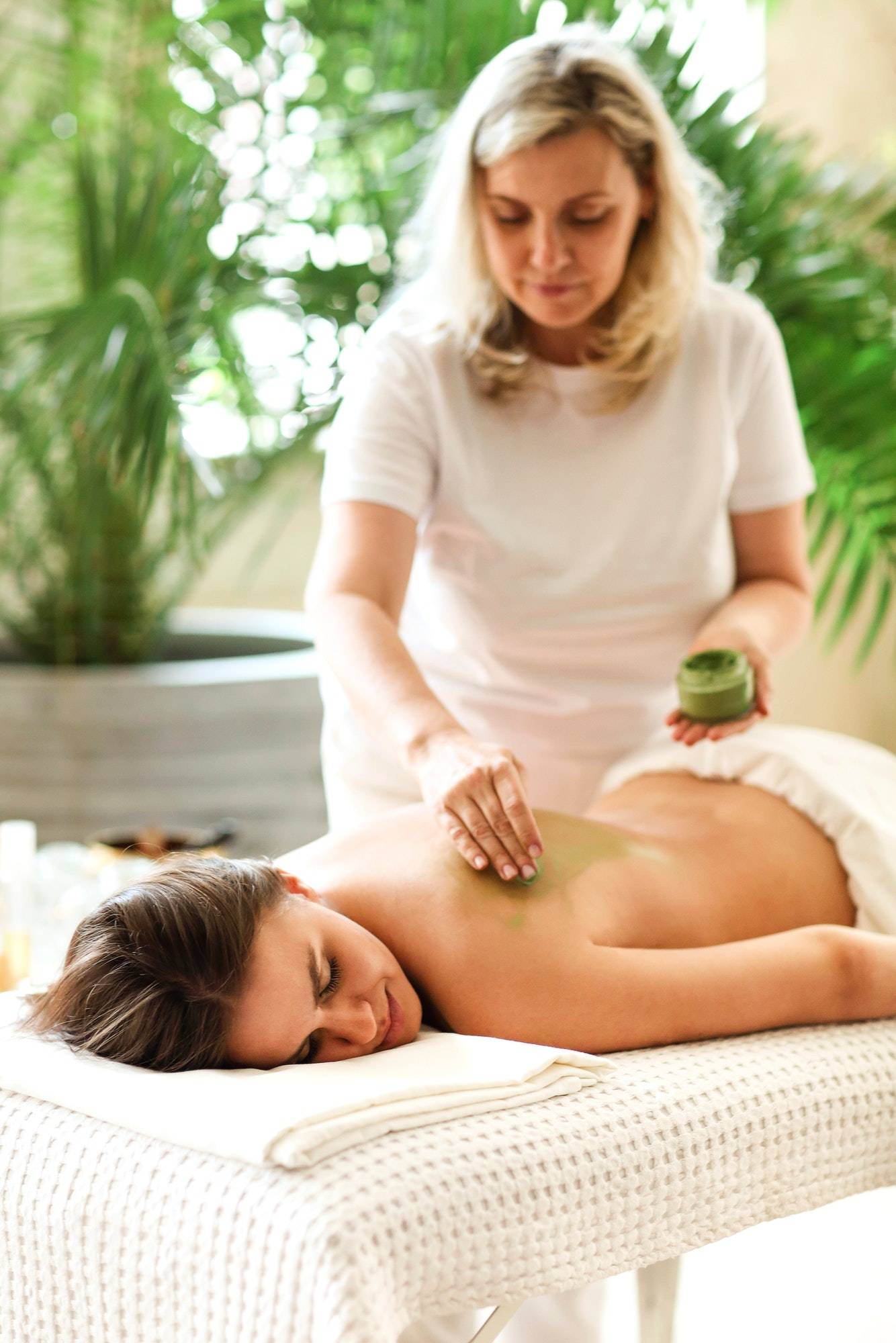 Woman receiving a relaxing clay mask treatment on her back at a best massage center near you in islamabad